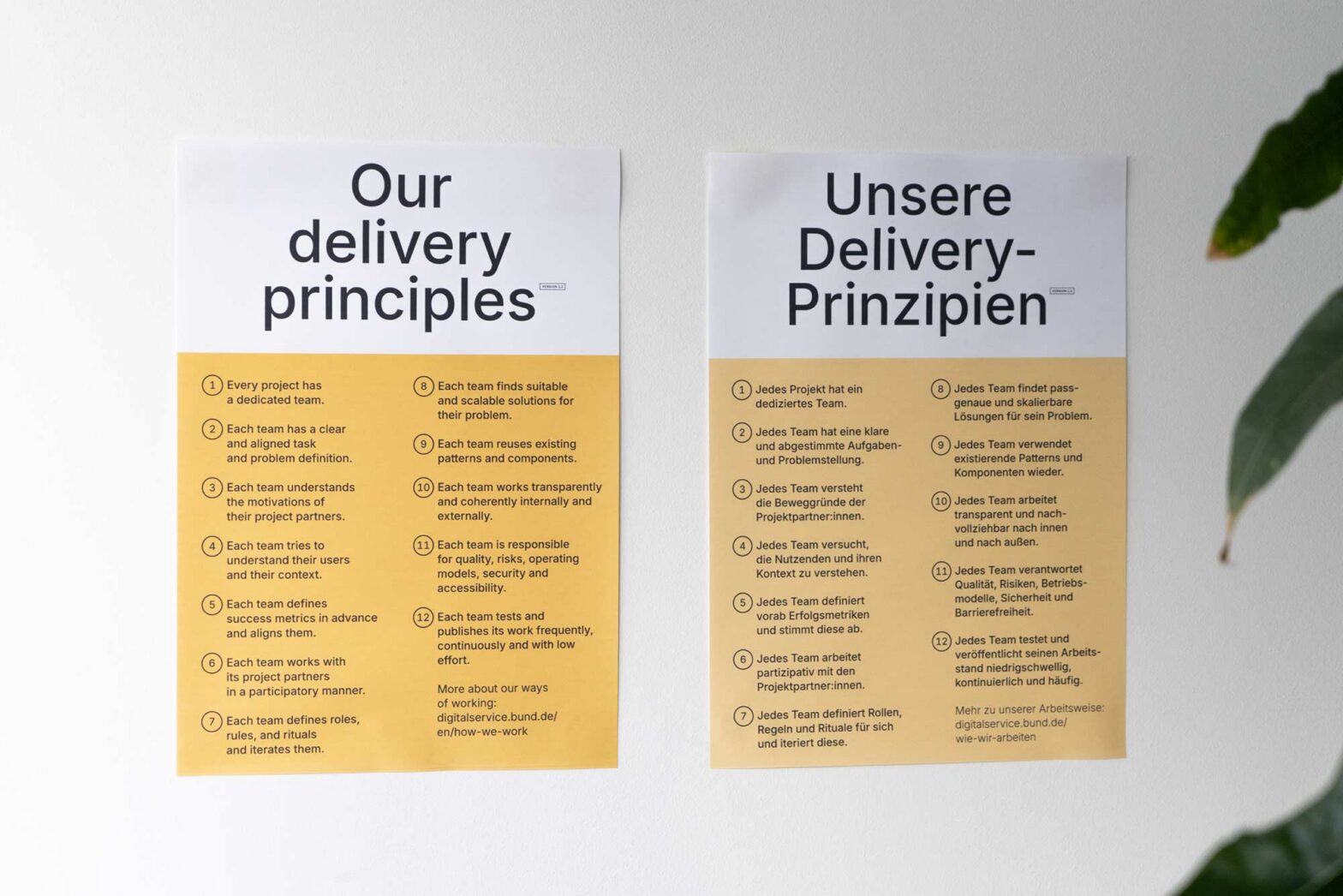 2 very similar posters on a wall – containing the same content of 12 delivery principles, one in German, one in English