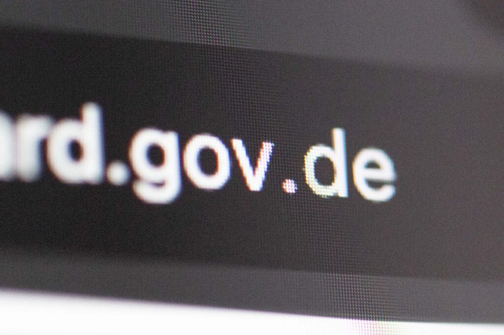 Closeup of an internet browser’s address bar showing a pixelated web address ending on dot gov dot de, indicating a German government website